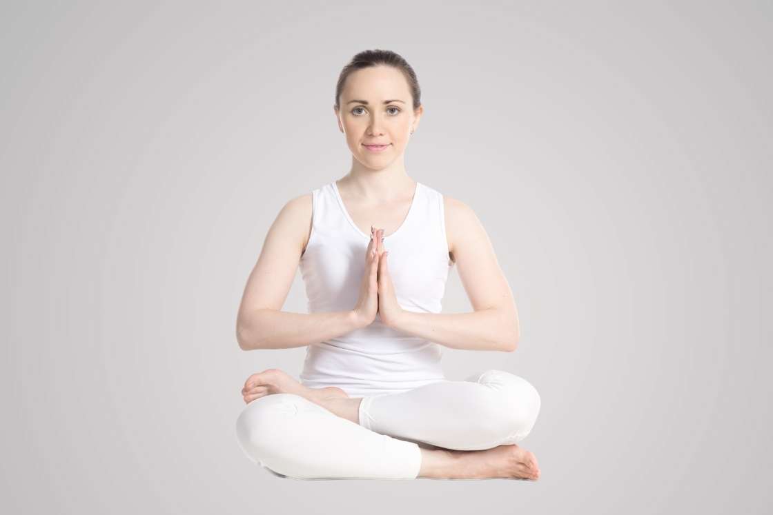 a woman's bare legs in the lotus yoga pose or padmasana using a